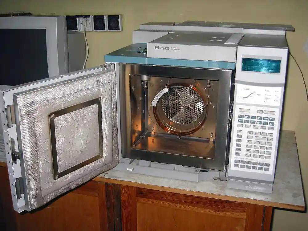 HP 6890 gas chromatograph with its column oven door open, showing the coiled capillary column and keypad