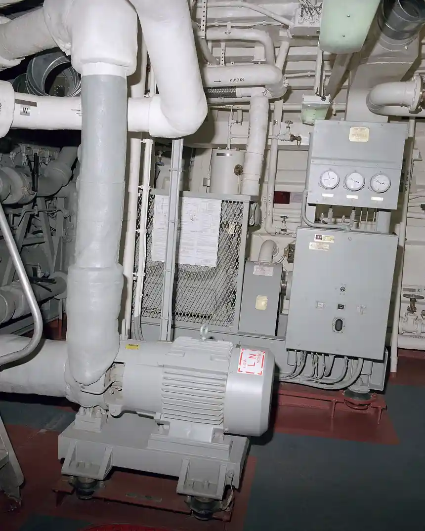 Air-conditioning machinery room aboard the frigate USS Kauffman: electric motor on resilient mounts, insulated piping and A/C plant gauge panel and control box