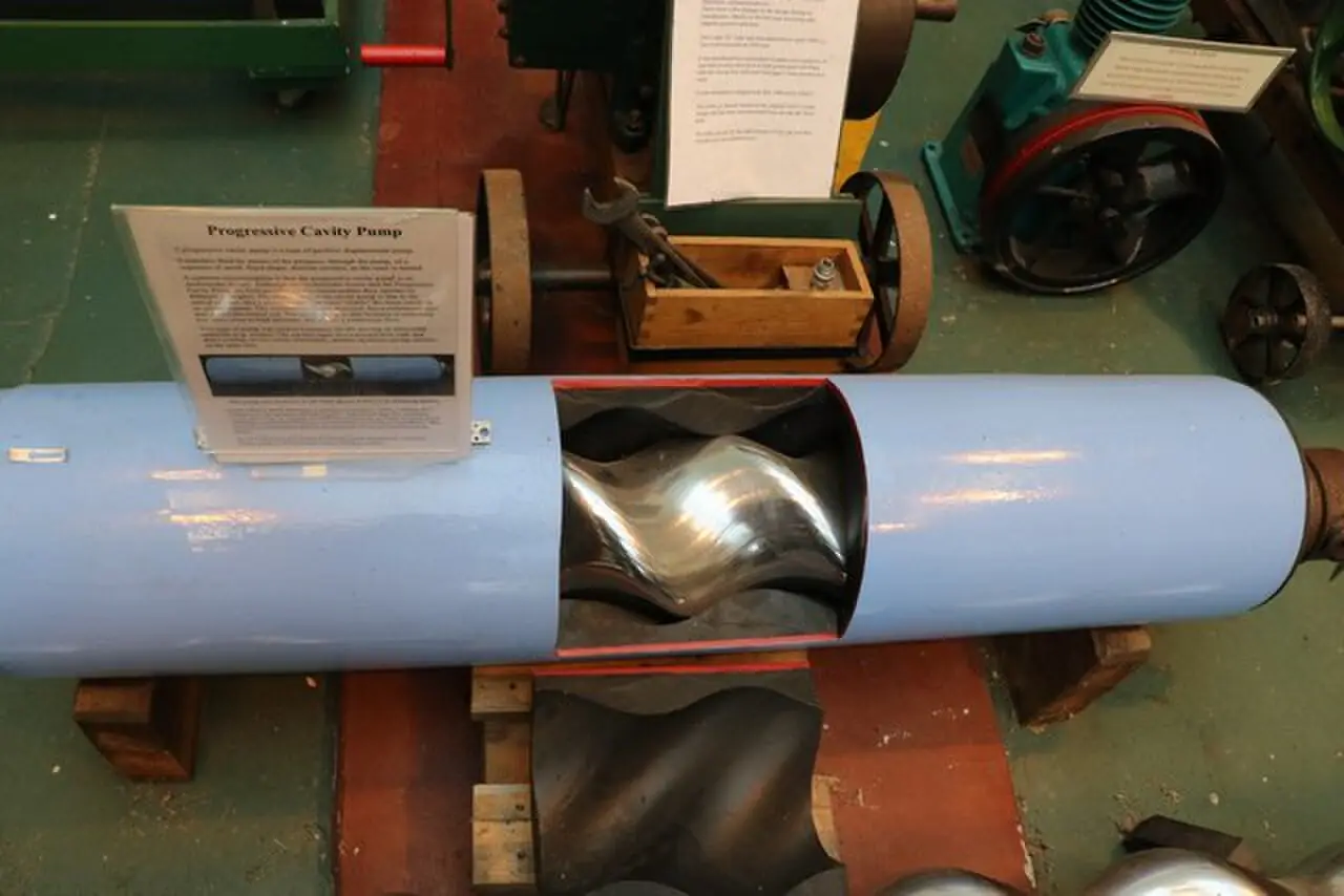 Cutaway of a progressive cavity sludge pump showing the polished single-helix metal rotor inside the pump body at Crossness Pumping Station