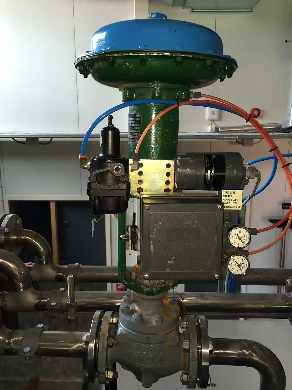 A Fisher sliding-stem control valve with a spring-and-diaphragm actuator and a side-mounted valve positioner, air supply tubing, I/P converter and pressure gauges installed on process piping
