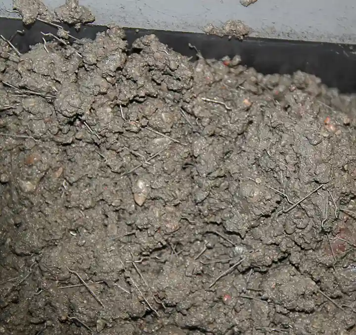 Fresh steel-fiber-reinforced concrete mix with discrete hooked steel fibers visible distributed throughout the wet matrix