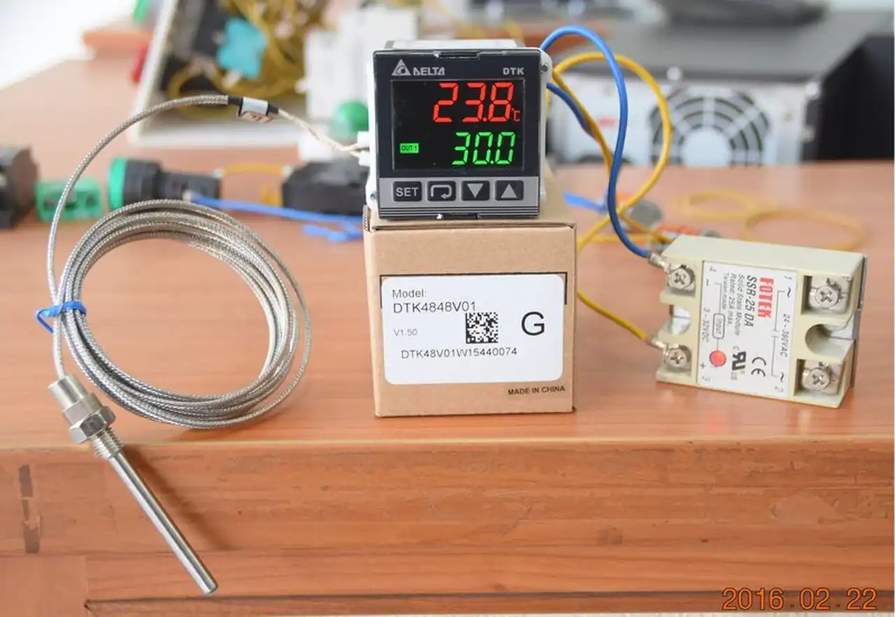 Delta DTK4848V01 DIN-panel PID temperature controller in operation, showing a red process-value display reading 23.8 and a green setpoint display reading 30.0, wired to a K-type thermocouple probe and a Fotek solid-state relay